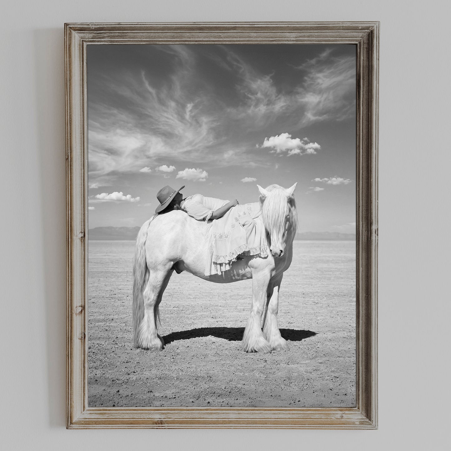 PASSAGE black and white cowgirl and white horse wall art shown in a weathered wood frame