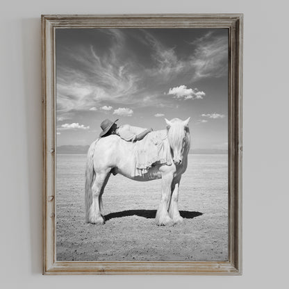 PASSAGE black and white cowgirl and white horse wall art shown in a weathered wood frame