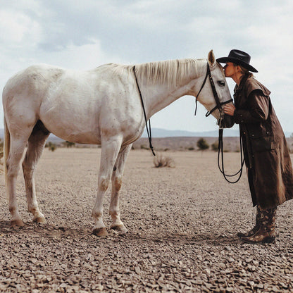 Woman kissing a white horse in the desert, featured in WHO NEEDS HUMANS wall art